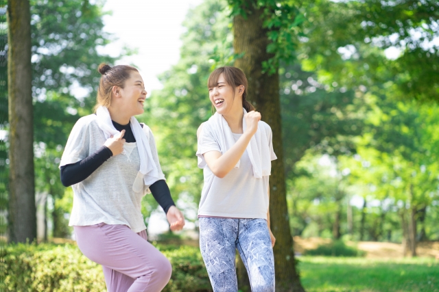 屋外で有酸素運動（ウォーキング）を楽しむ女性2人組