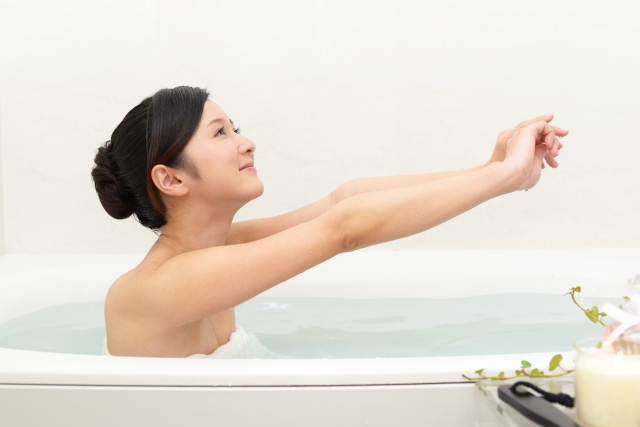 お風呂で湯船につかり、体を温め血流を促している女性