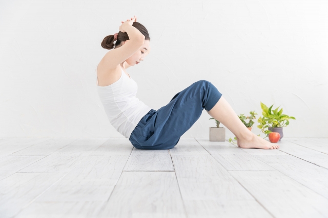 自宅（屋内）で、ダイエットなどにも効果的な、自重筋力トレーニングを行う女性