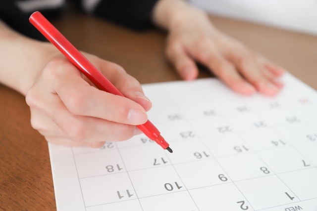 カレンダーで計画を立てる女性のイメージ