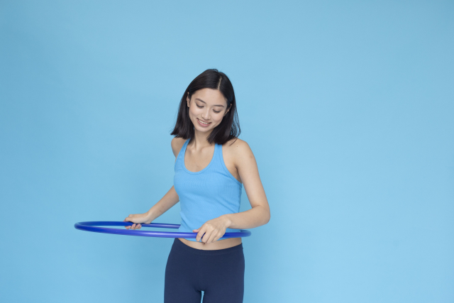 スポーツウエアでフラフープをする女性