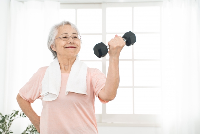 重りを使った筋力トレーニングを行うシニア世代の女性