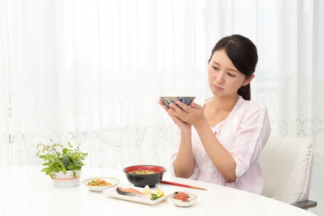 食事の前で悩んでいる女性